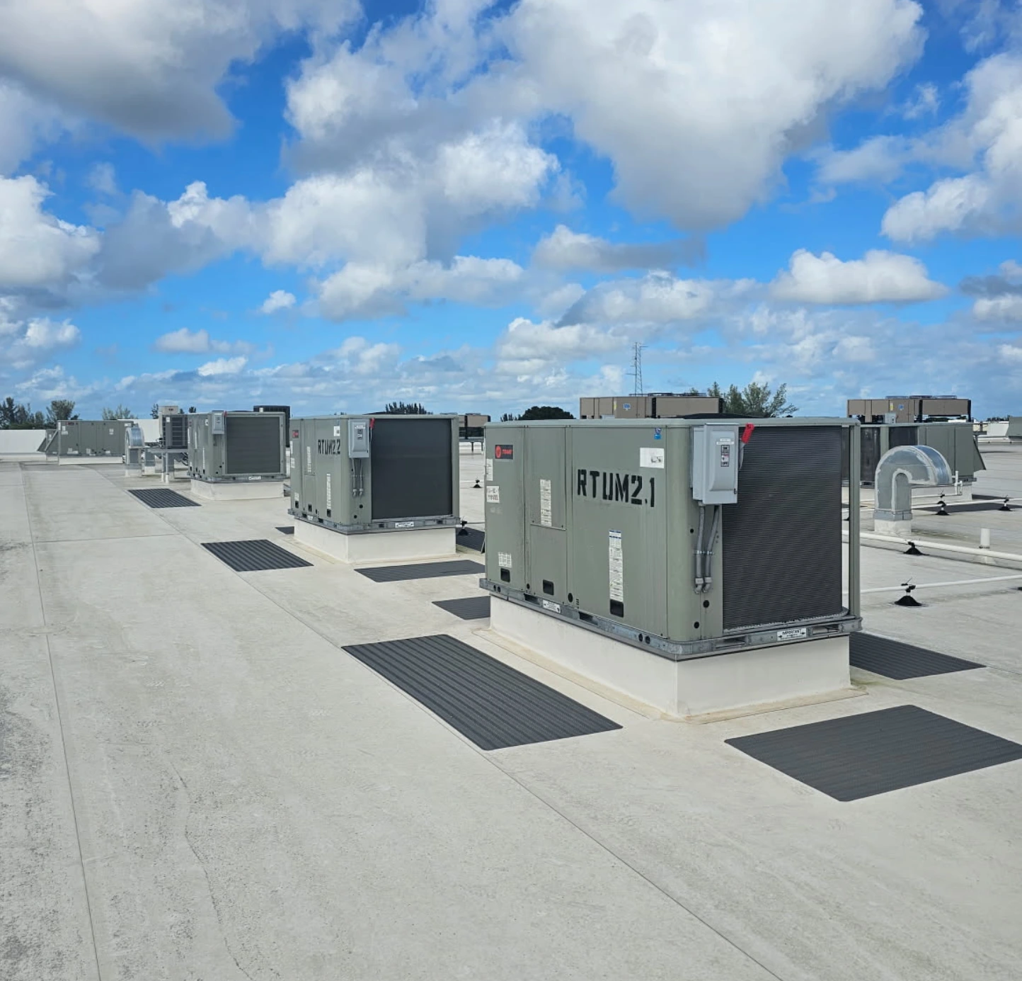 A group of air conditioners sitting on top of concrete.